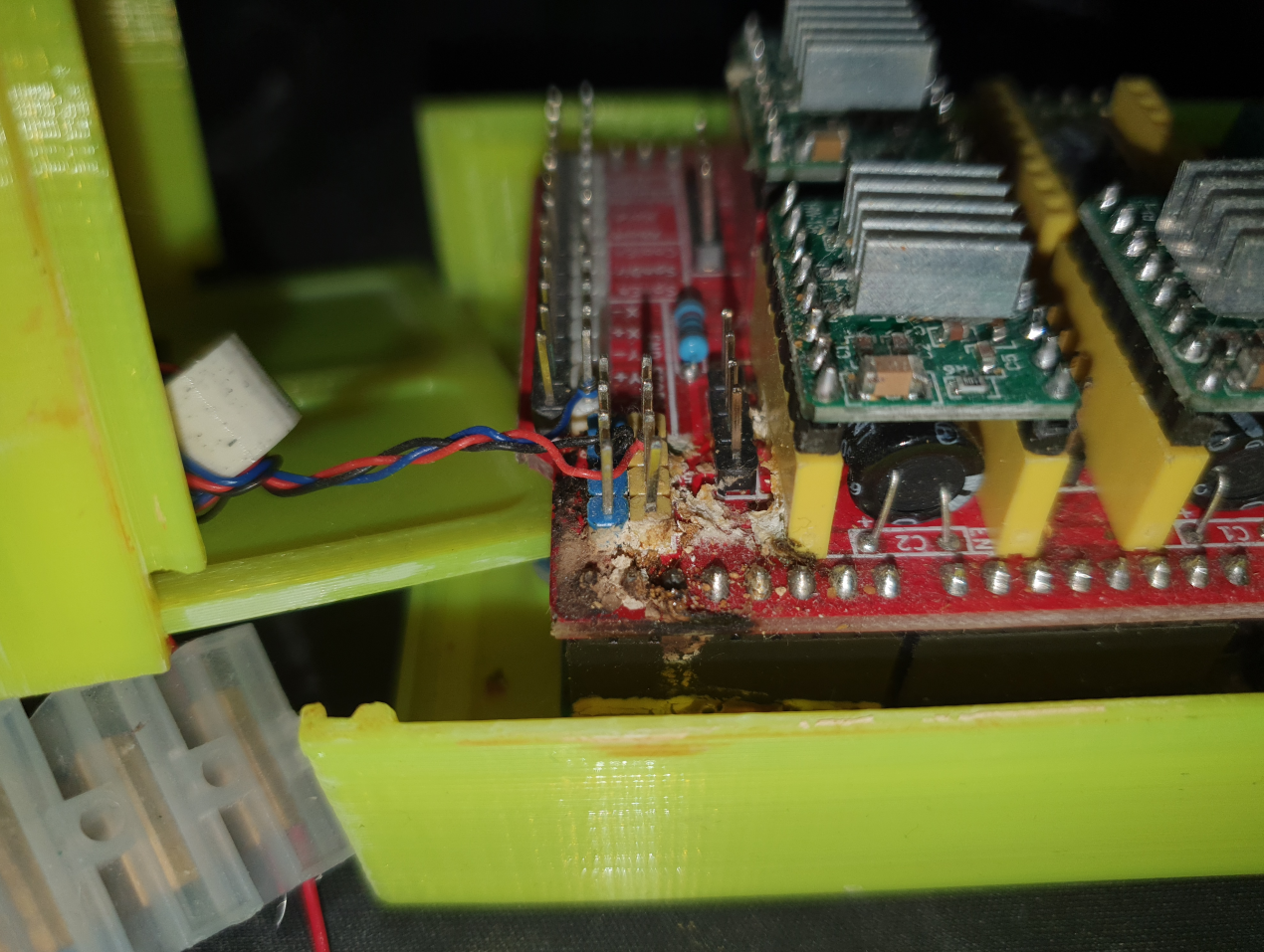 A corroded circuit board that is an Arduino shield on an Arduino with some black goop and white powder and 3 wired are connected to it